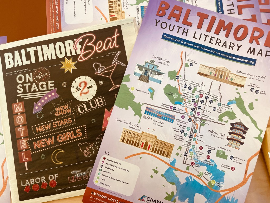 An close-up of two printed materials: the 'Baltimore Beat' community paper and the 'Baltimore Youth Literary Map' resource guide. Both materials feature vibrant graphics and details on events and venues for arts & culture in the city.